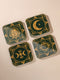 A set of four square coasters with a glossy finish, featuring celestial gold designs on a deep forest green background. Each coaster showcases a unique motif: a stylized sun with a serene face, a crescent moon with a star, a triple moon symbol with botanical elements, and a radiant sunburst. The intricate gold linework creates an art deco-inspired, mystical aesthetic. Made from durable materials, these coasters blend elegance with celestial charm.